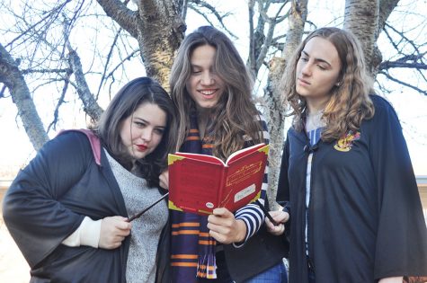 Seniors and lifelong Potter fans Lindsay Moran, Michelle Kerstein, and Caroline Koricke read a copy of Fantastic Beasts and Where to Find Them,