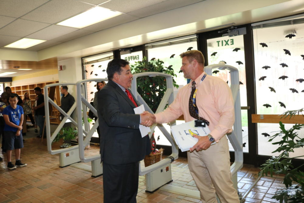 CMS Superintendent Clayton Wilcox presents CMS Principal of the Year to principal Rick Parker.