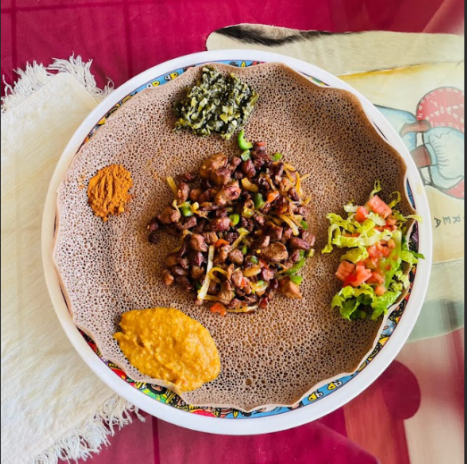 The dish pictured is a classic Ethiopian foods such as, lentils and injera with ye beg tebs.