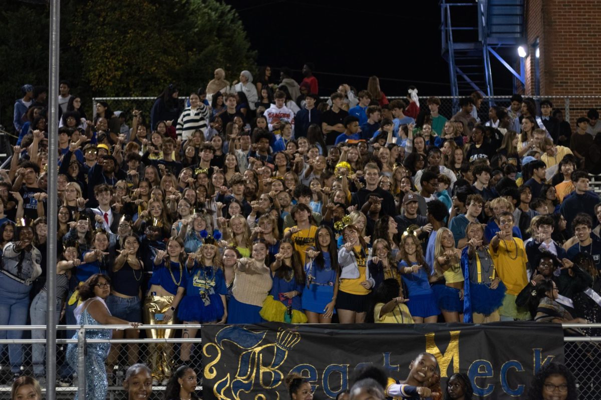 East Meck student section throws up their signature eagle sign. Homecoming usually draws a big student section to the crowd. 