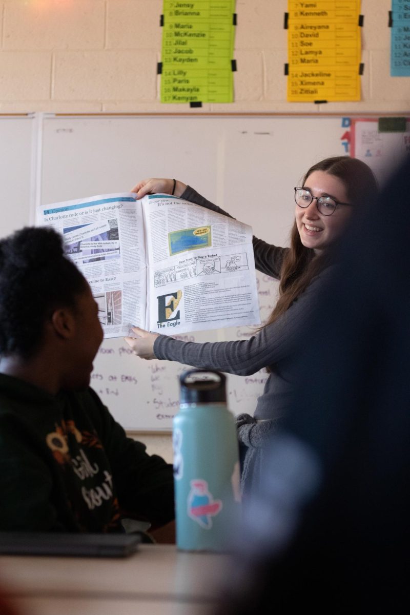 Cleo Strauss presents a newspaper section she likes in front of the team. A small ceremony shouting out the hard workers on the team was held before passing newspapers out. 