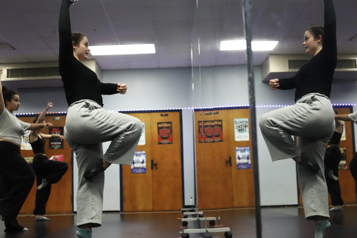 Senior Greta Herring leads practice in front of the mirror, which allows dancers to improve their form.