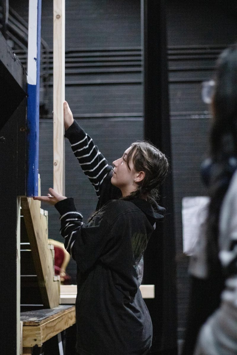 Dorothy Allen-Slattery measures a plank before using it to construct a new set piece.