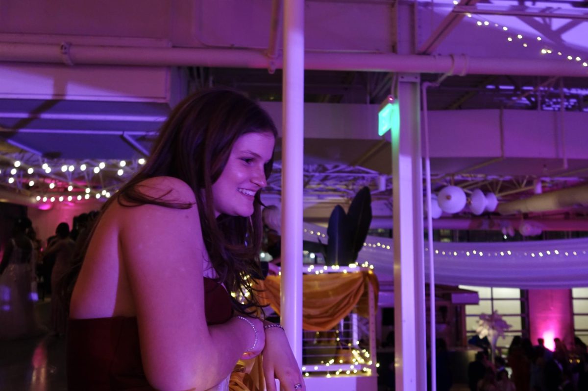 Grey Packard smiles while watching the dancers at room. Prom is an opportunity for students to Dres up and see all of their friends in an exciting setting.