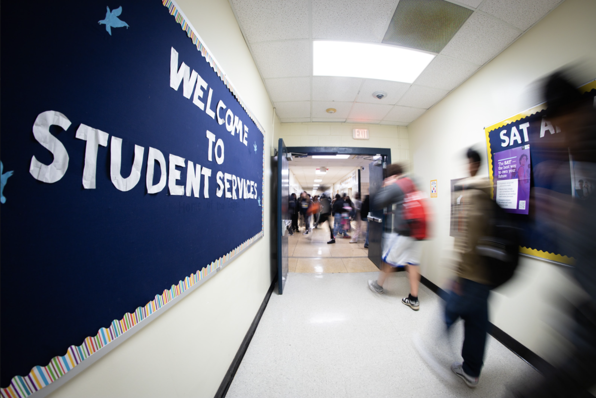 Students walk in and out of student services during a transition between classes. Throughout the day, the student services staff corrects system errors, meets with students and organizes lists of resources.
